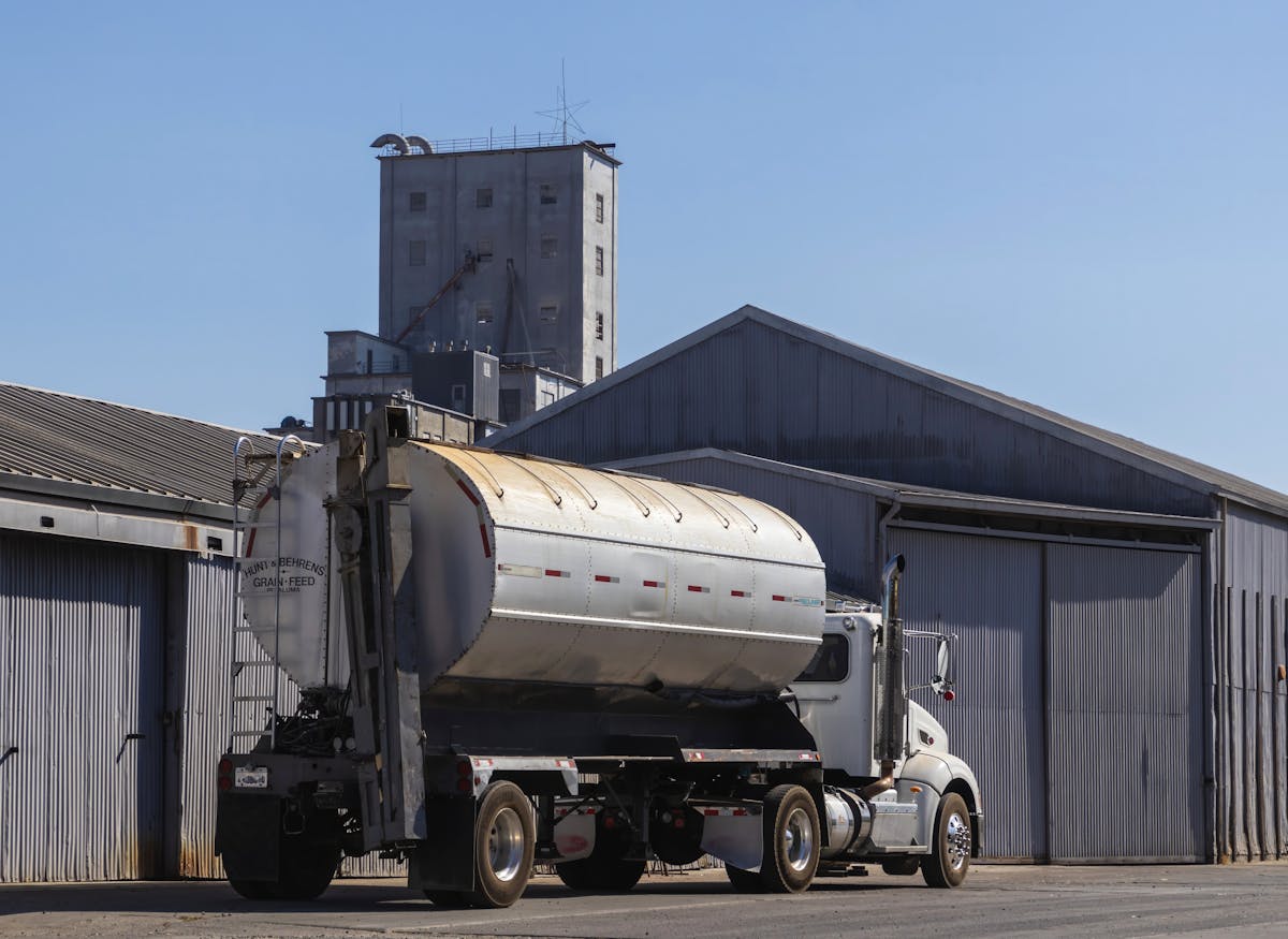 Truck positioned beside an industrial warehouse facility