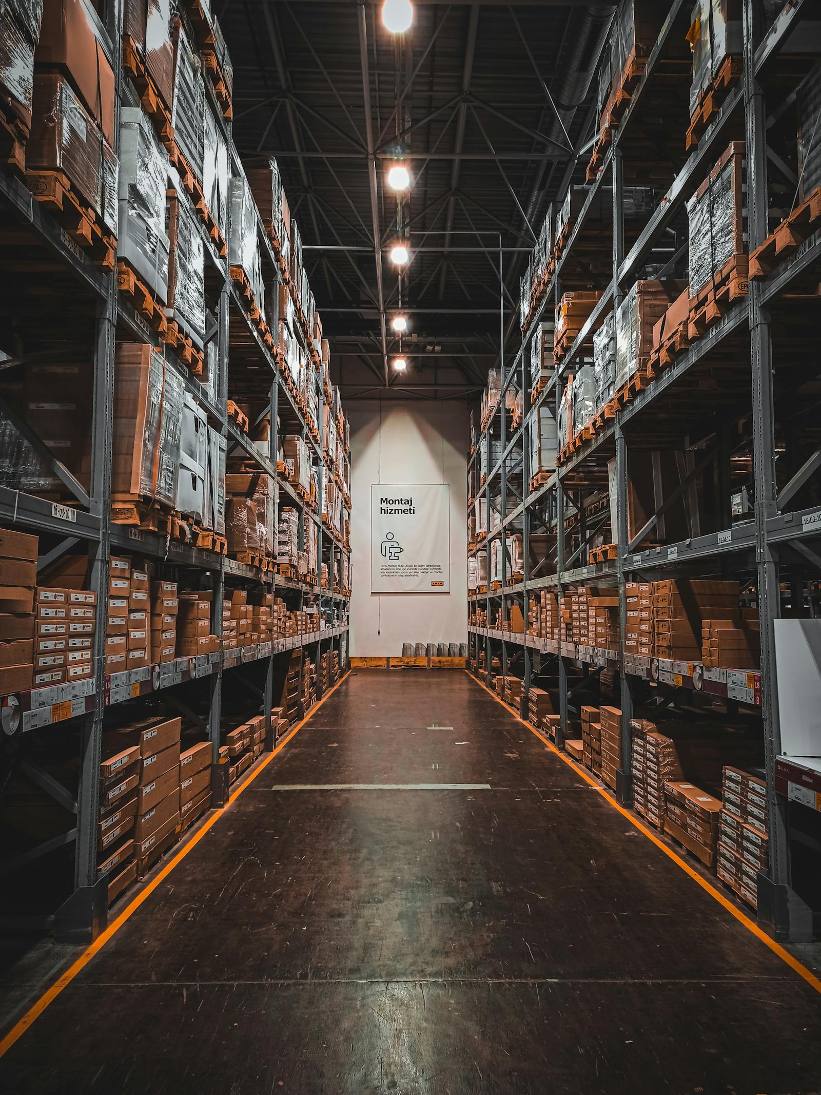 Warehouse aisle with organized pallets and inventory shelving